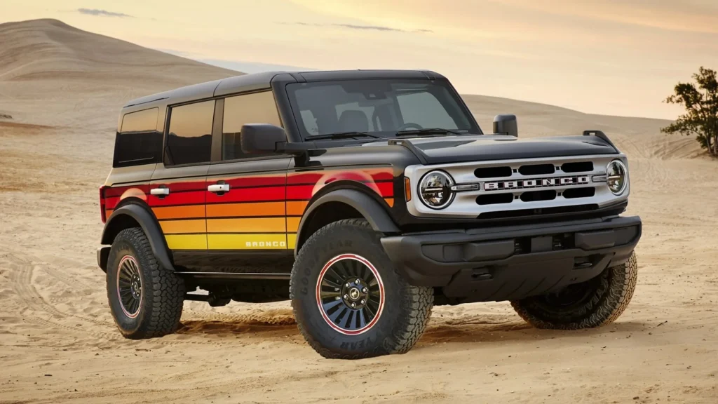 2025 Ford Bronco® in black with retro sunset graphics parked on sandy terrain