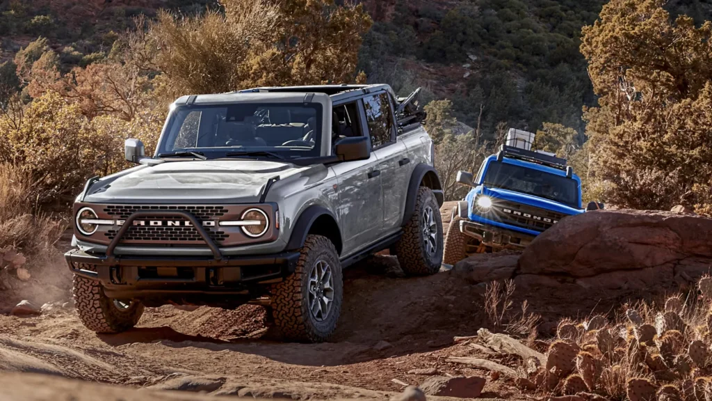 2025 Ford Bronco® climbing over rocky desert terrain with a second model following behind