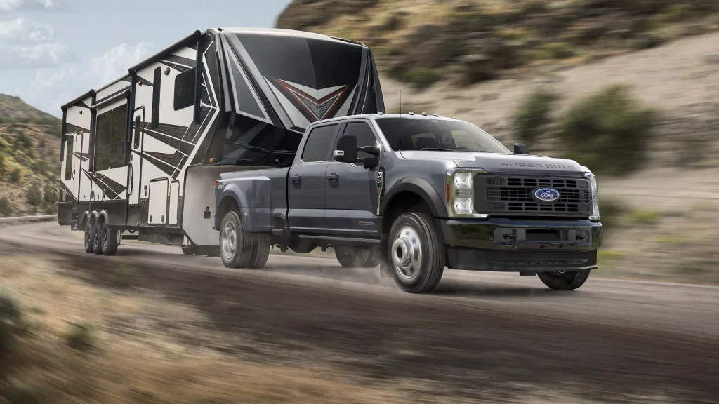 2025 Ford Super Duty® dually truck towing large fifth-wheel RV trailer through desert canyon