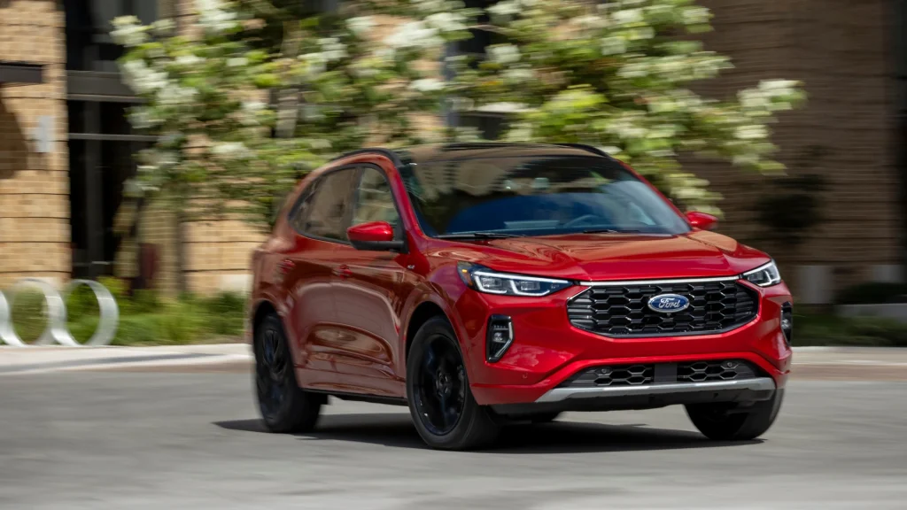 2025 Ford Escape ST-Line Hybrid SUV in motion through a vibrant neighborhood.