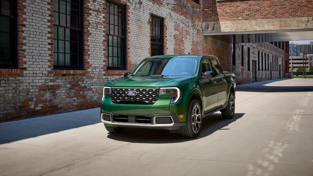 2025 Ford Maverick® compact pickup in green parked by urban brick buildings.