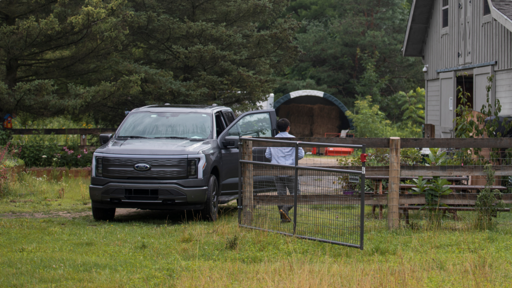 2024 Ford F-150® Lightning parked near a barn showcasing its modern electric truck design.