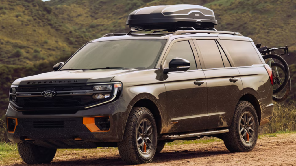 2025 Ford Expedition® Timberline SUV off-road with roof cargo box and mountain backdrop.