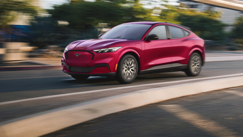 2025 Ford Mustang Mach-E® in motion, red electric SUV with sleek curves and sporty stance.