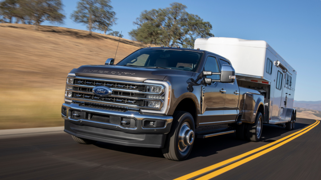 2025 Ford Super Duty® F-350® towing a large trailer on highway, emphasizing hauling strength.