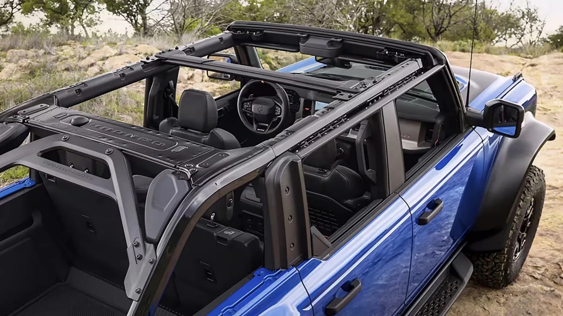 Overhead view of 2025 Bronco® with open roof panels and rugged black interior seating.