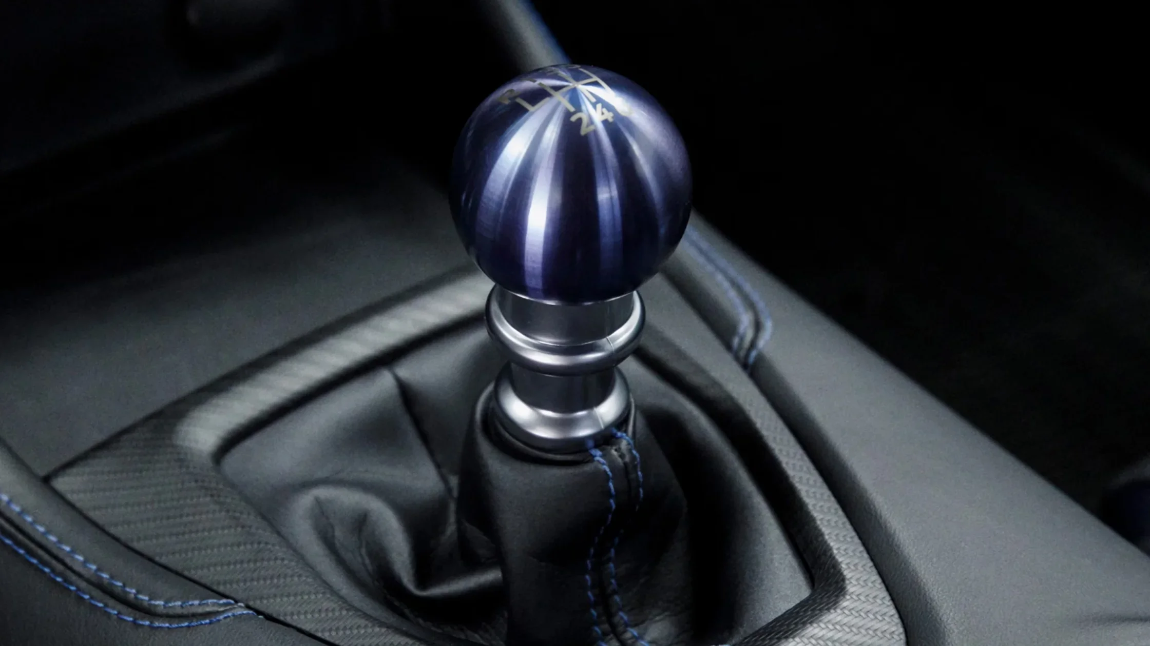 Close-up of 2025 Ford Mustang gear shifter with blue anodized knob and contrast stitching