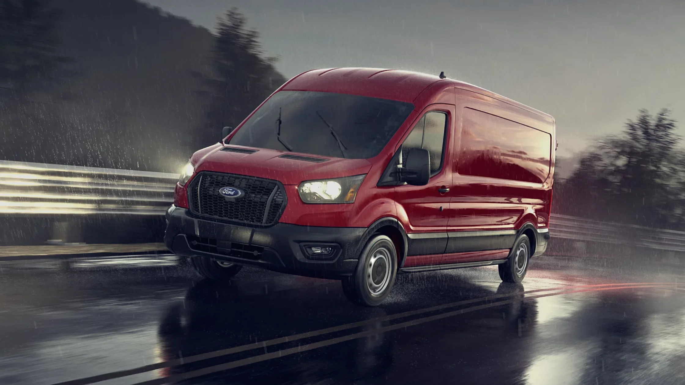 2025 Ford Transit cargo van in motion on wet road during rainfall with headlights on