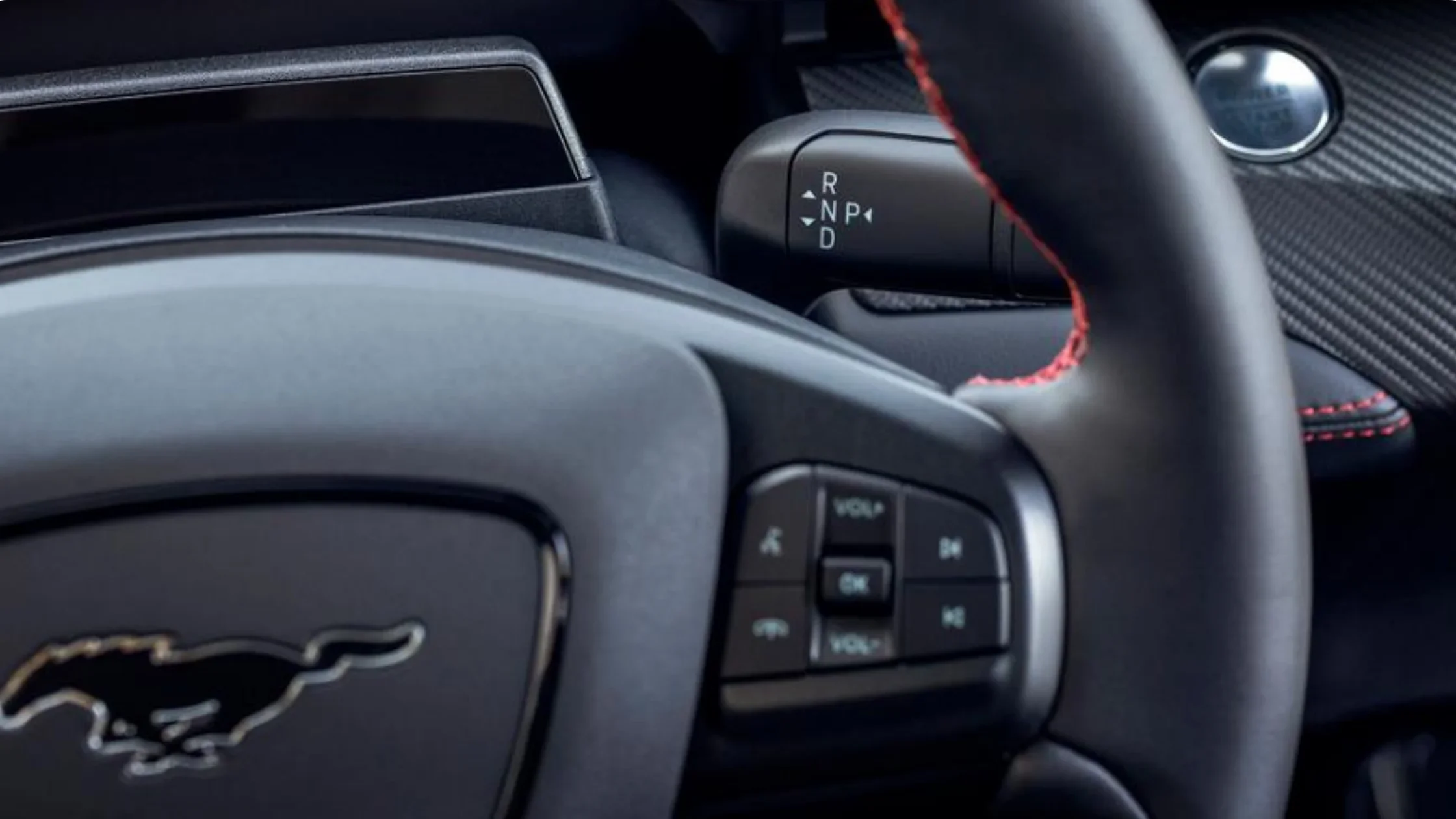 2025 Mustang Mach-E® steering wheel detail with drive mode selector and red stitching accents